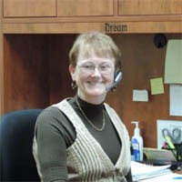 Candace Shira wearing a headset in her office.