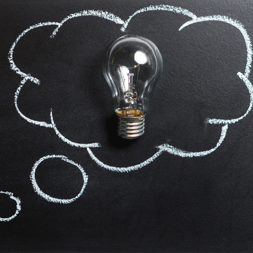 Light bulb inside a chalk-drawn thought bubble