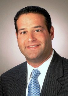 Professional headshot of a smiling male team member.