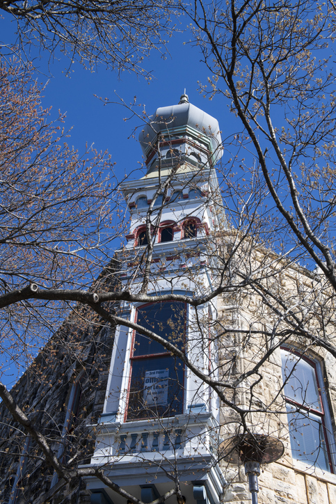 Historic stone building with ornate tower and blue sky