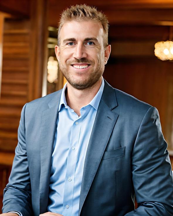 Smiling man in a blue blazer and light blue shirt.