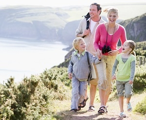Family hiking on a coastal trail by the sea.