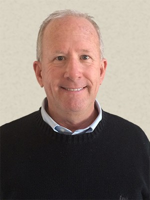 Smiling man with short hair in a black sweater.