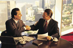 Two professionals shaking hands in high-rise office