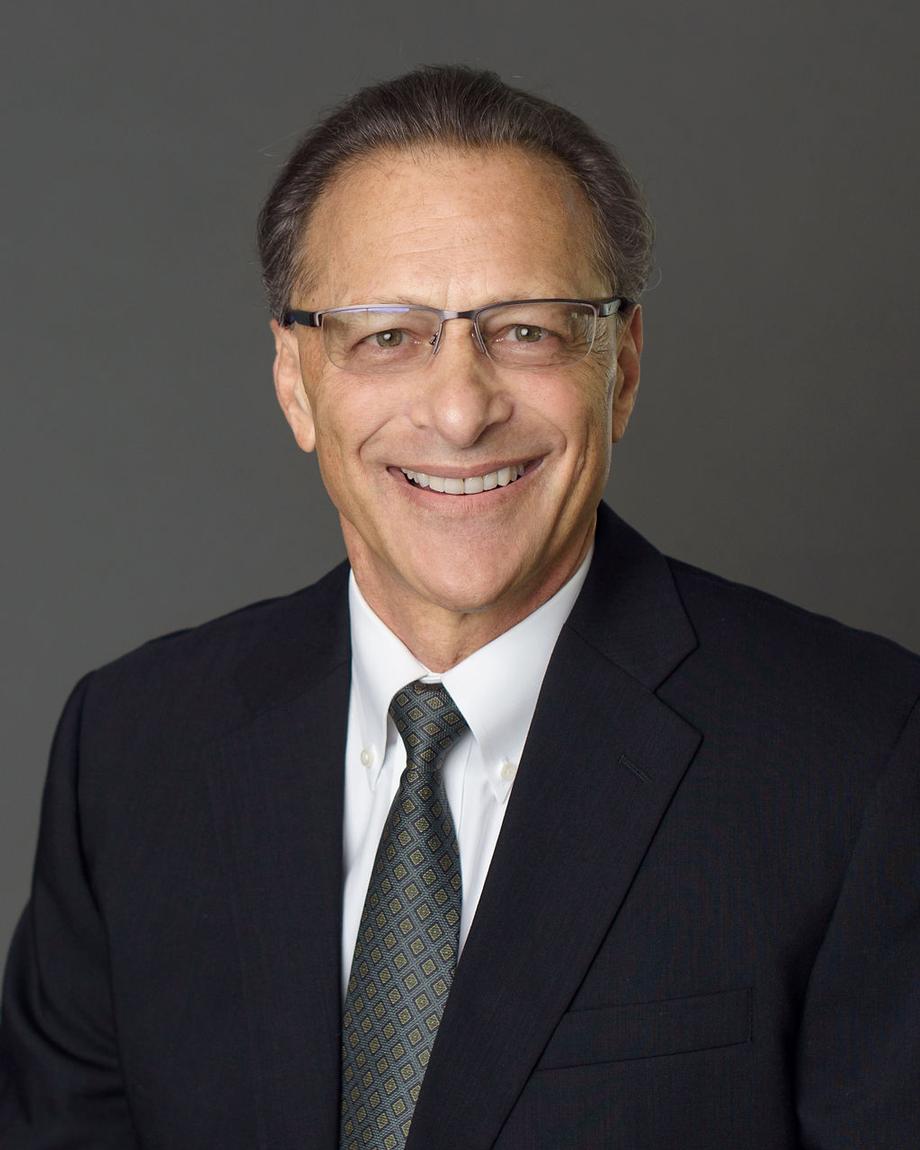 Smiling male advisor in a suit and glasses.