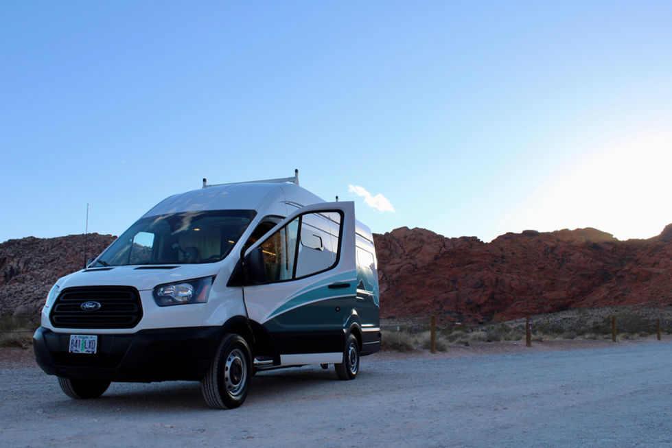 A campervan with a view of Utah’s unique rock formations and expansive blue sky.