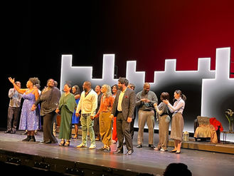 A line of composers and librettists taking final bows on stage after a performance of three new operas.