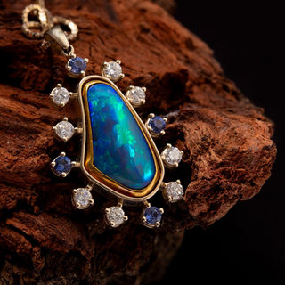 Solid Australian opal pendant with 24ct yellow gold bezel, 18ct white gold setting, diamonds and tanzanites.