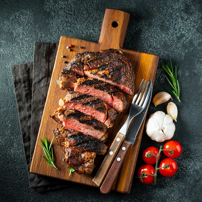 Medium rare steak cut on a wooden cutting board