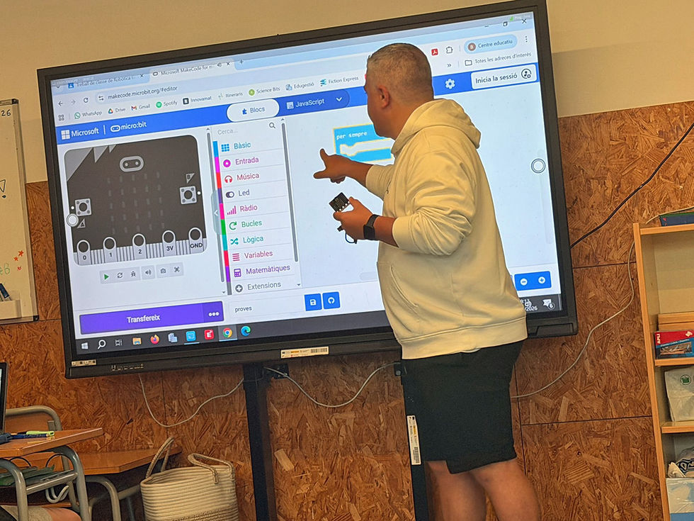 Nauczyciel w trakcie zajęć, stojący przy dużym monitorze.