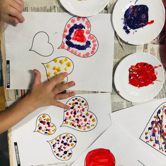 Dziecko w czasie zajęć plastycznych tworzy walentynkowe dekoracje