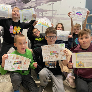 Grupa uczniów prezentuje swoje prace - plakaty prezentujące prawa dziecka.
