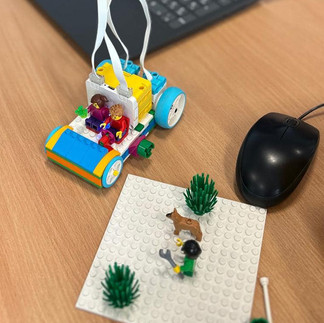 Dzieci w pracowni informatycznej budują z klocków Lego pojazdy.