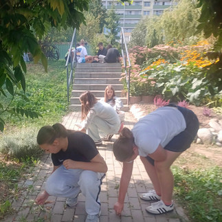 Dziewczęta w trakcie prac porządkowych w ogrodzie społecznym