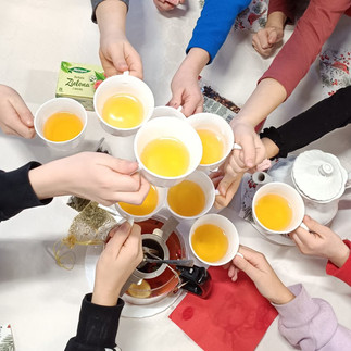 Filiżanki z herbatą w rękach dzieci.