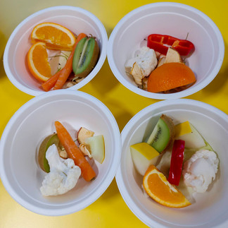 Cztery miseczki wypełnione cząstkami kolorowych owoców.