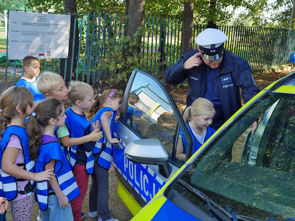 Policjanci demonstrują dzieciom samochody policyjne,