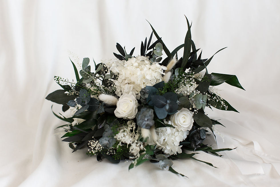Miniaturbild: Großer, wilder Brautstrauß aus weißen Infinity-Rosen, Hortensien und dunklem Eukalyptus auf hellem Untergrund.