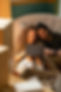 Photo of couple, sitting closely together sharing a laptop computer.