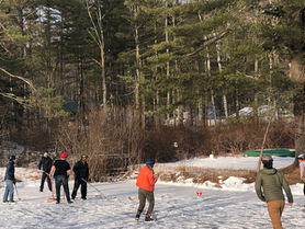 Gould Farm community members ice skating on the pond behind Main House.