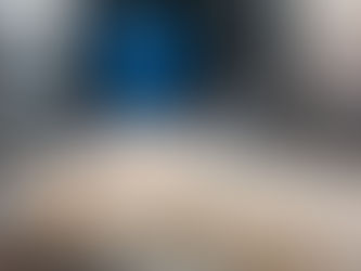 A cheesemaker wearing a blue apron in the Gould Farm creamery flipping cheese molds.