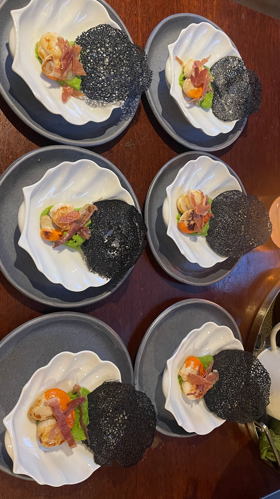 Scallops, pea puree and serrano ham with a squid ink tuile london restaurant hotel