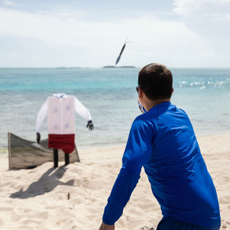 Teams rotate through competitive challenges along a beach in the Bahamas.