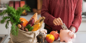 woman putting vegetable savings into piggy bank
