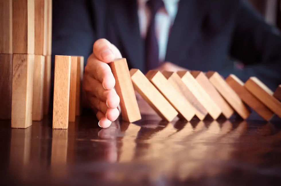 Preventing financial setbacks in Minneapolis, Minnesota – A business professional stops a row of falling dominoes, symbolizing small-scale landlords in the Twin Cities taking action against rising property taxes and financial challenges.
