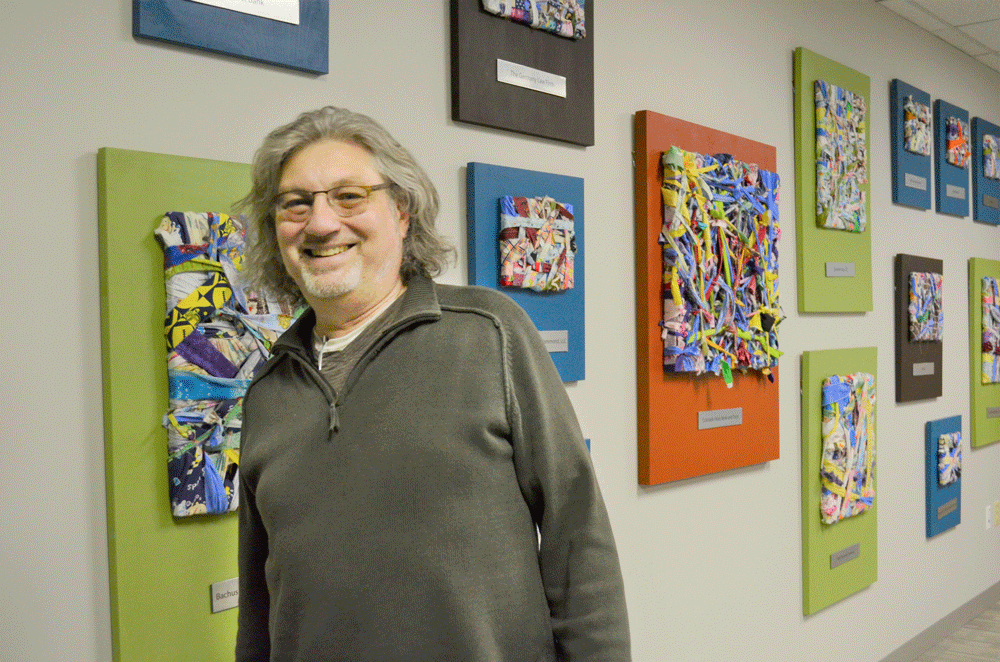 Arnie Swenson standing in front of artwork.