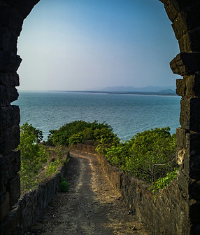 a view of the ocean through an arch in a