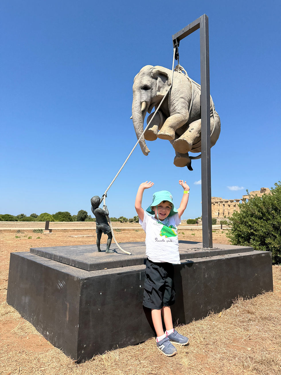 Jennifer's grandson in front of a statue in Sicily.