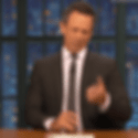 Seth Meyers sitting at a desk, looking overwhelmed and counting rapidly on his fingers as if listing a never-ending series of items.