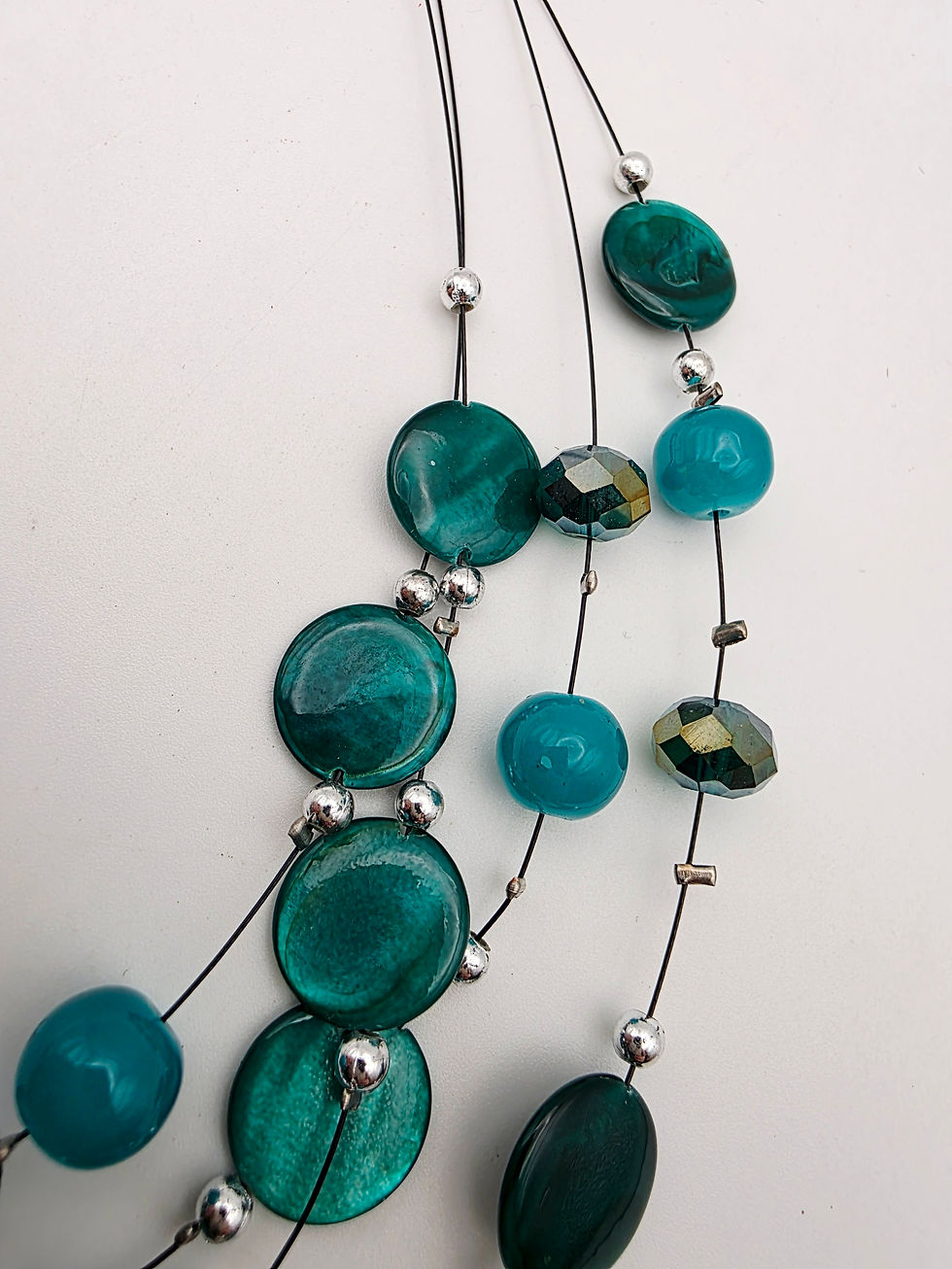 Thumbnail: Detailed view of faceted iridescent glass beads and smooth turquoise cabochons