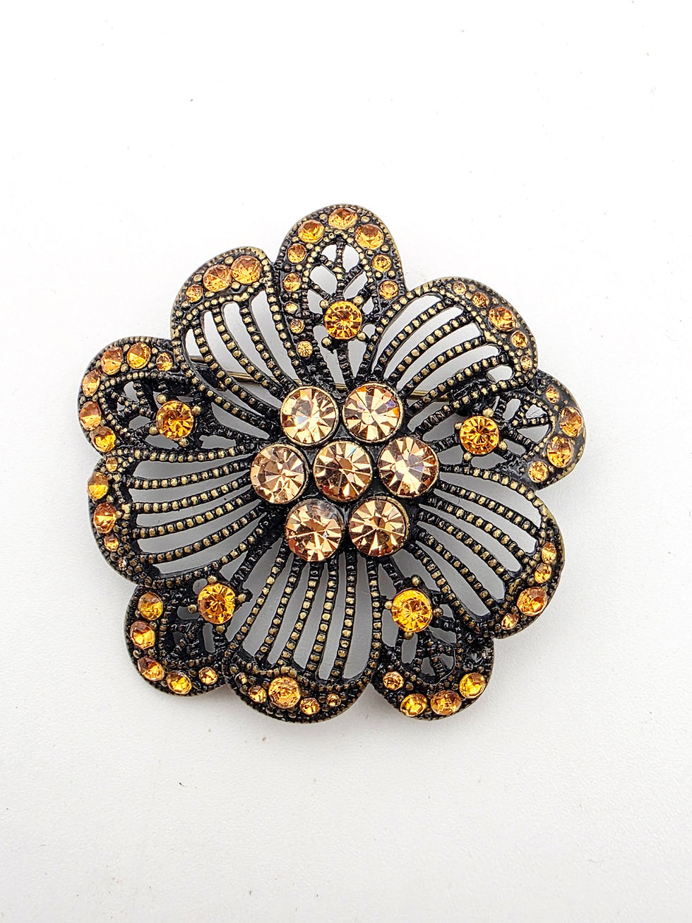 Front view of vintage amber rhinestone flower brooch in antiqued bronze tone