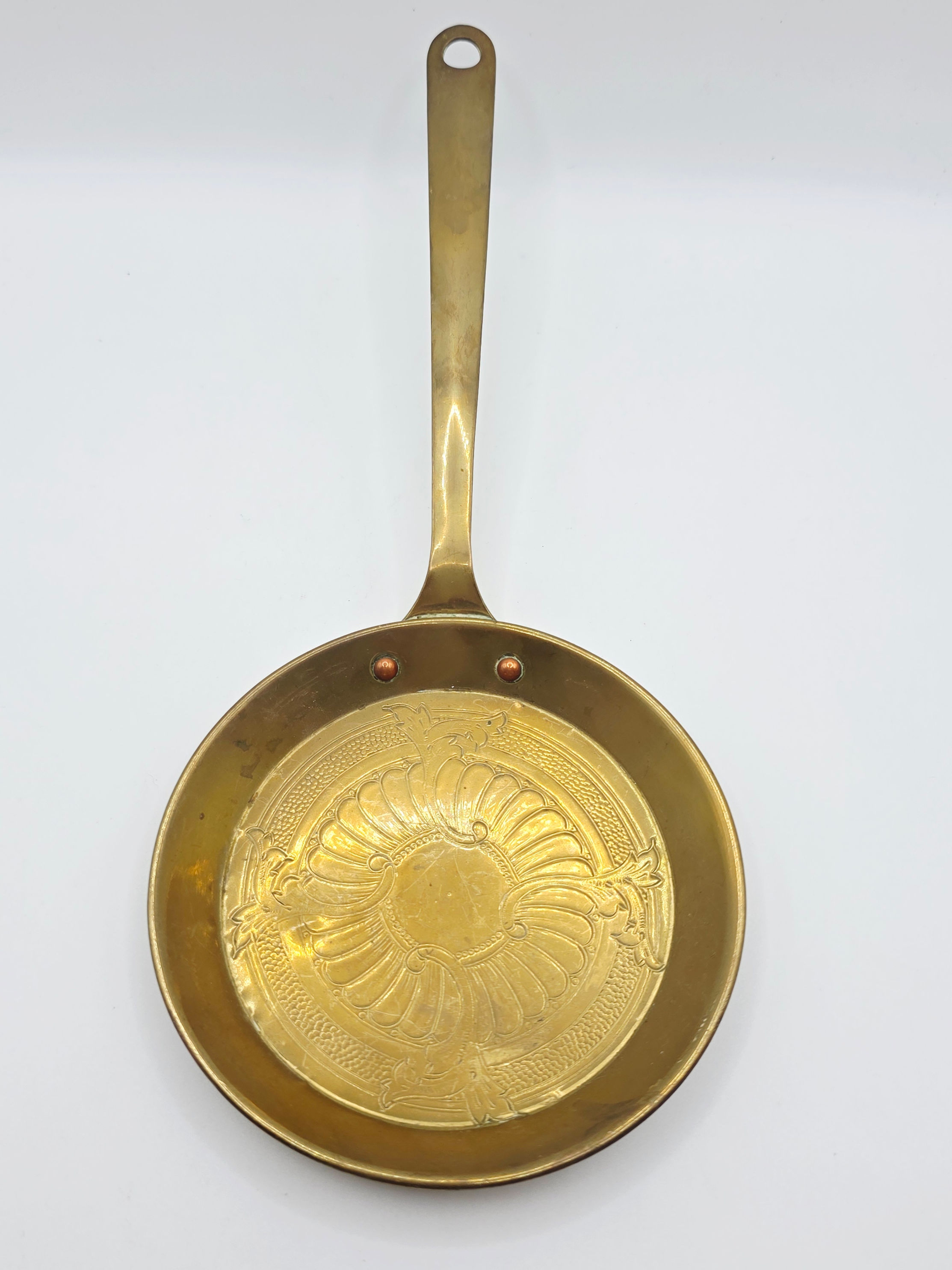 Vintage brass Weba Ware miniature skillet pan lying flat on white backdrop.