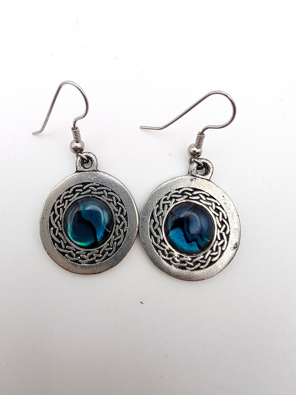 Vintage Astra Ceard Scotland pewter Celtic knot drop earrings with blue abalone shell cabochons on white background.