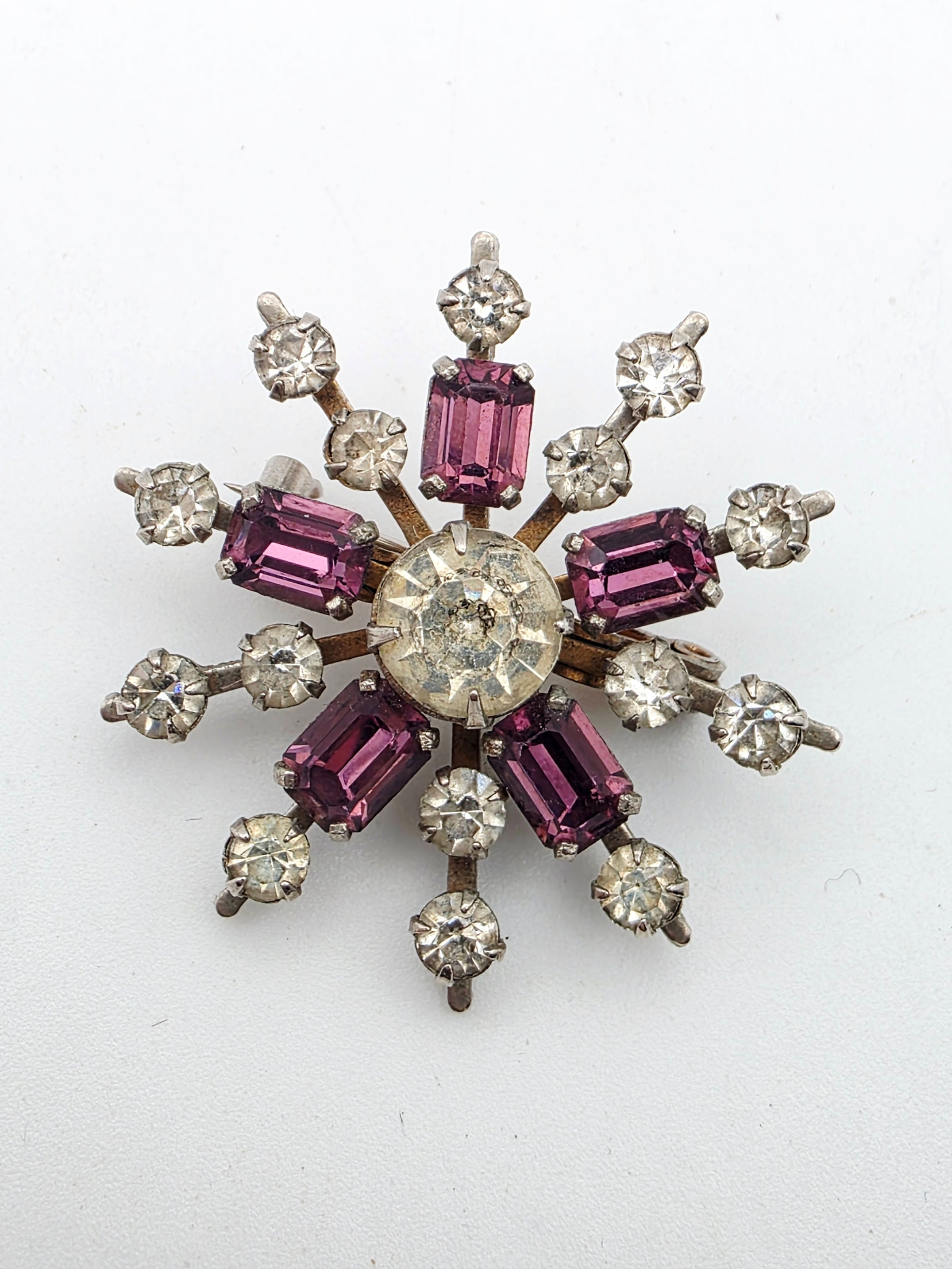 Front view of mid century c. 1950s amethyst purple and clear rhinestone starburst brooch