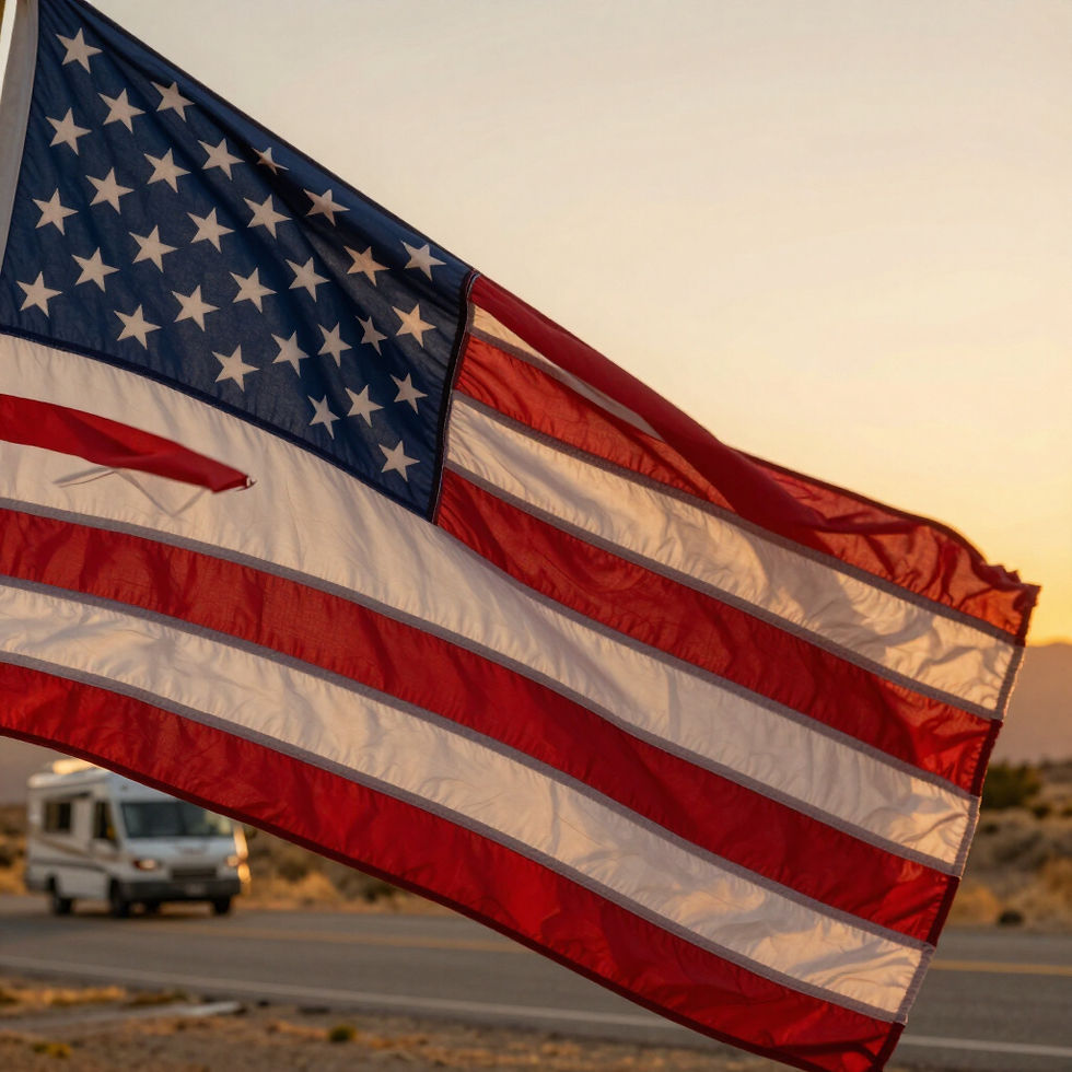 American flag waving near an RV on a road at sunset.