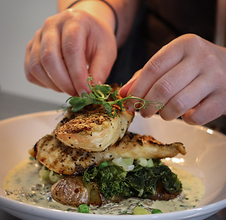 Chef finishing a seasonal dish made with locally sourced ingredients at The Bird Westhay.
