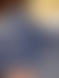 Hand holding open Le Fournil’s navy blue menu, showing the Parisian breakfast and gourmet baguette options on a marble table.