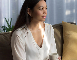 Natural light portrait of an entrepreneur, sipping coffee at home, embodying calm and creativity by StudioEnBlanco.