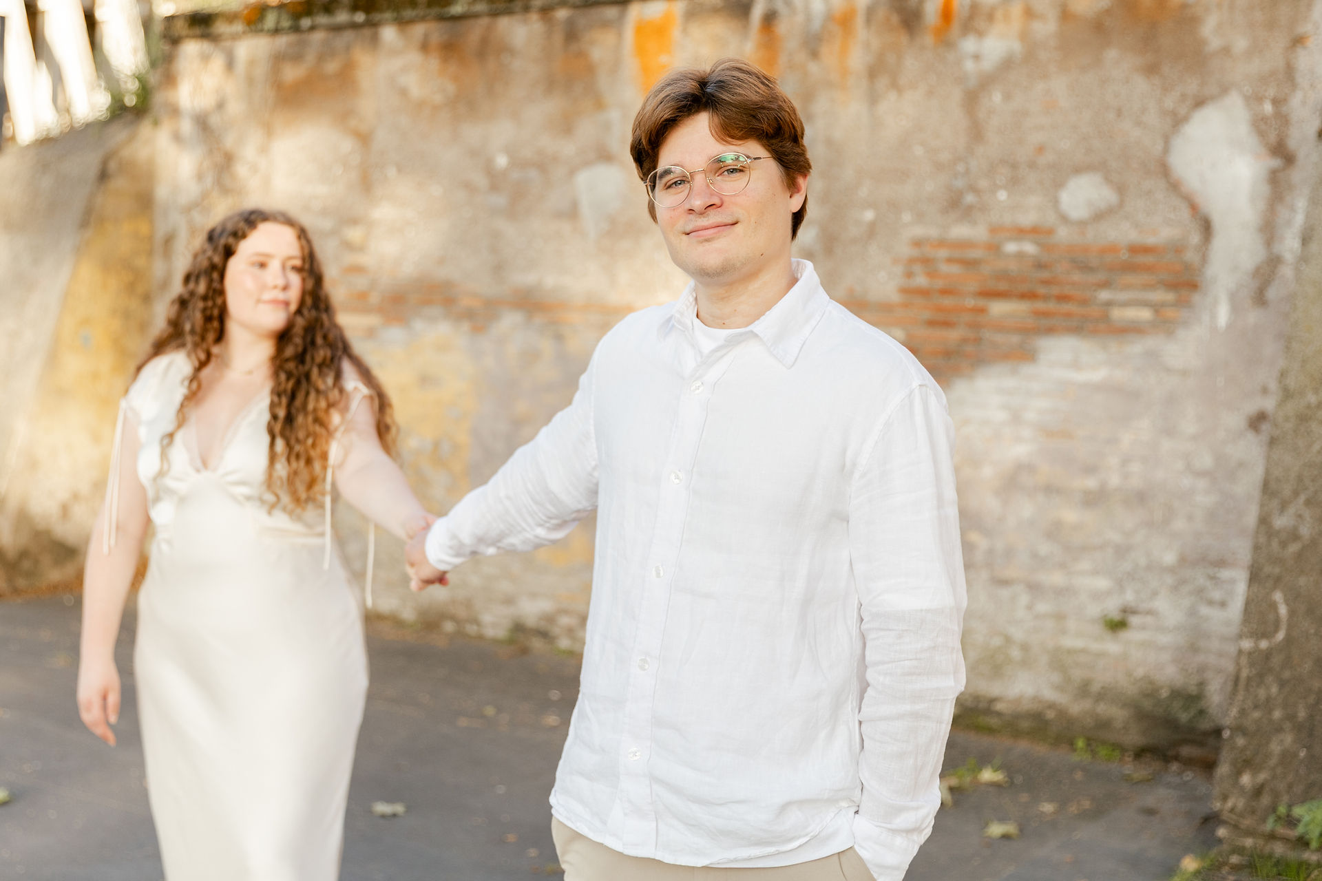 Husband standing in front of bride holding hands