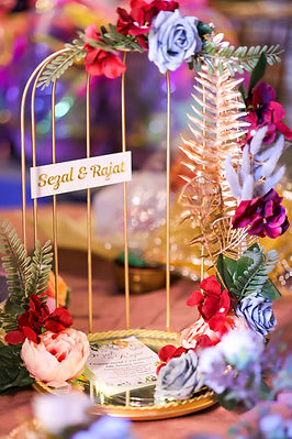 Couple in white wedding attire sharing a kiss under floral décor — wedding ceremony, bridal couple photography.