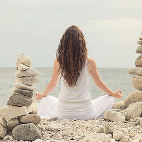 Kvinna som mediterar på strand