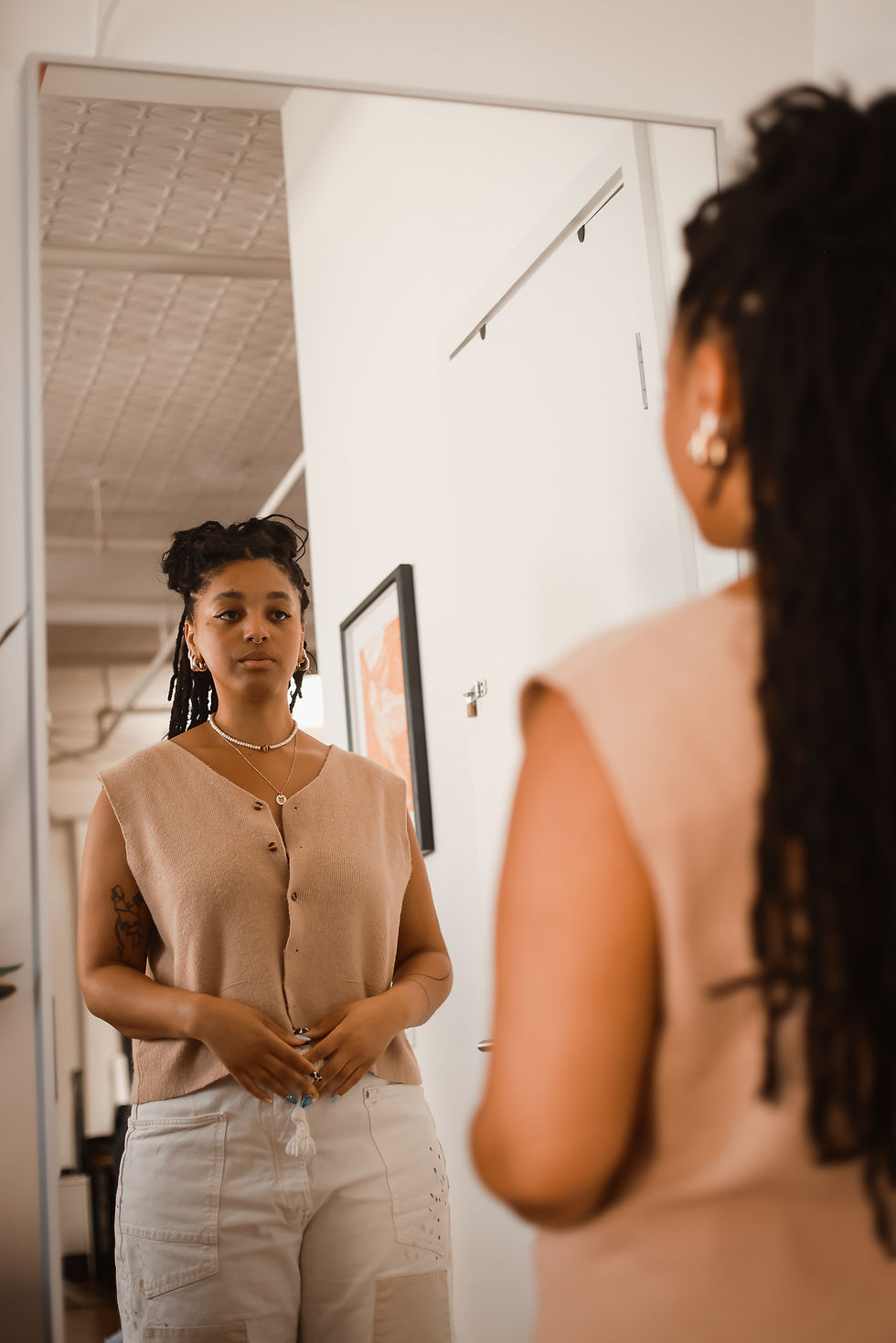 Woman gazing into mirror, symbolizing introspection and life transitions