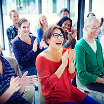 Group of happy people singing together, showcasing the social and creative energy of in-person workshops.