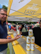 Thai beer stall vendor at Southampton Thai Festival showing beer cans display under festival tent canopy with customers