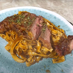 Steak with creamy peppercorn sauce and fresh pasta