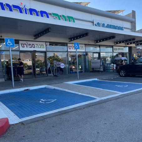 חניון של מרכז מסחרי עם חניות נכים מסומנות ושילוט אנכי